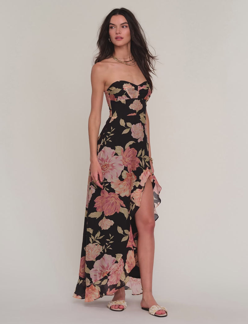 Woman wearing a floral strapless dress with a slit. 