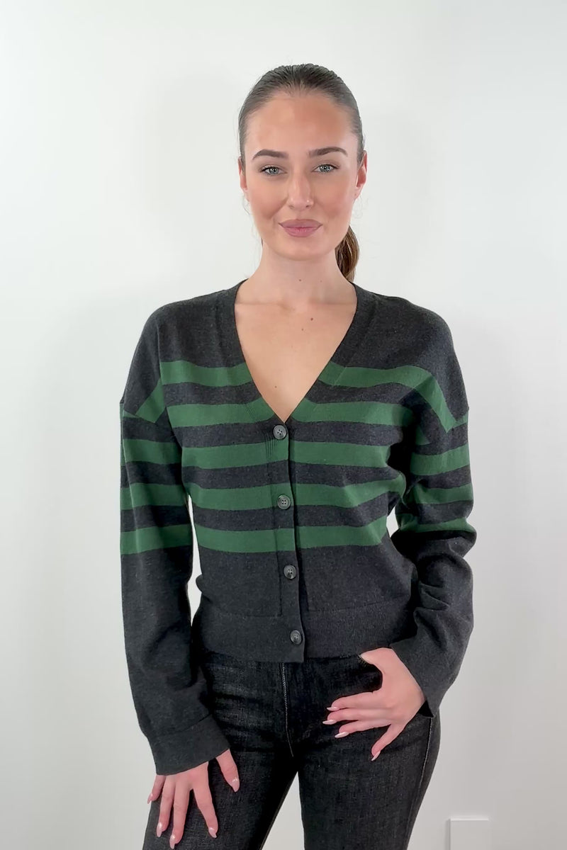 video of woman wearing black and dark green striped cardigan witth black buttons