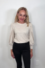 Video of a woman wearing a blouson cuffed sleeve beige top