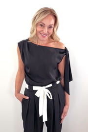 Video of woman wearing a wide neckline off the shoulder top in black