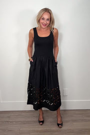 Video of a woman wearing a black cotton dress with cut outs in the bottom