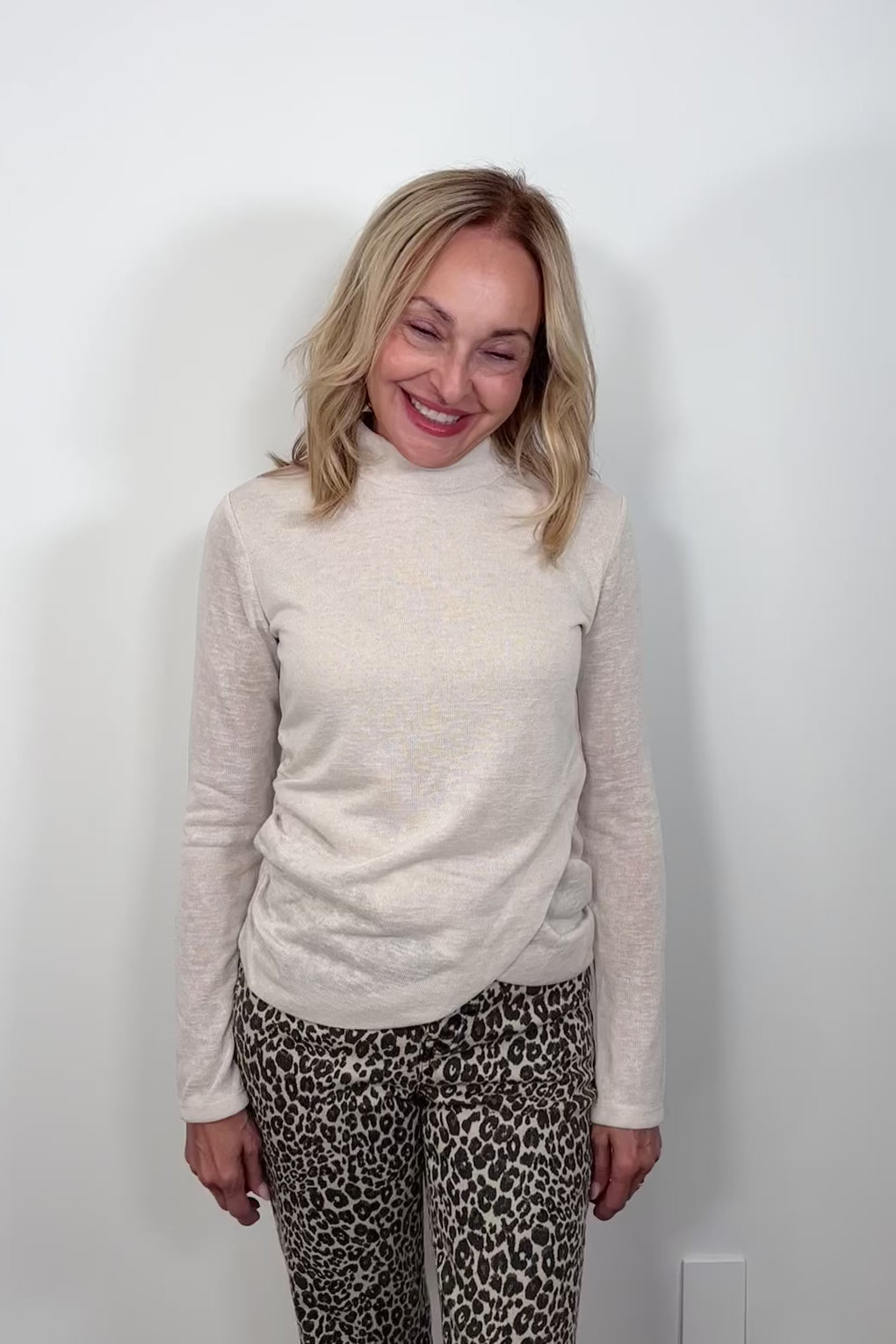 video of a woman wearing a light long sleeve draped beck top