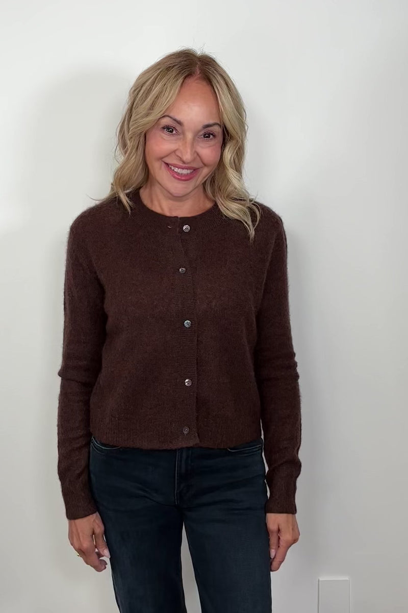 Woman wearing a brown cashmere and silk blend cardigan closed turning around to show the back.
