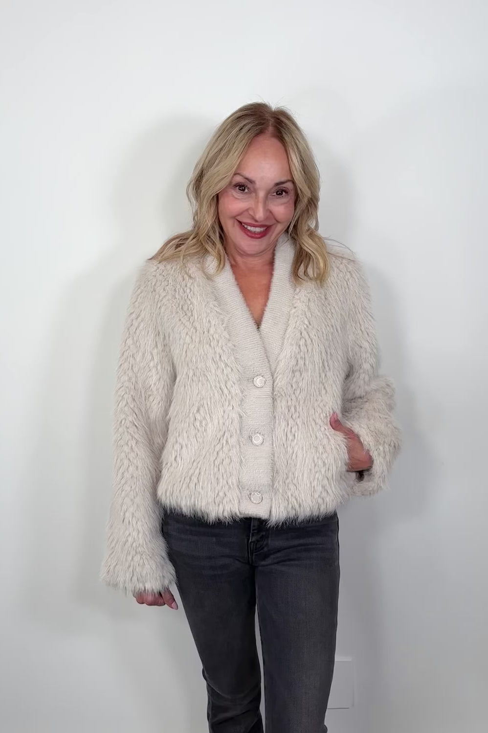 Video of a woman wearing a three button cream jacket