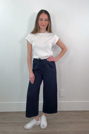 video of a woman wearing a navy ankle length wide leg pant