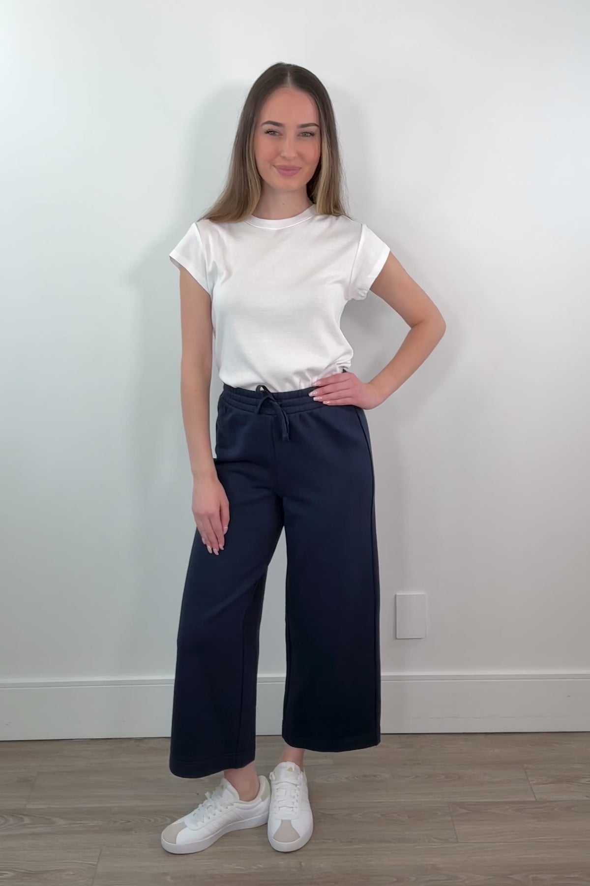 video of a woman wearing a navy ankle length wide leg pant