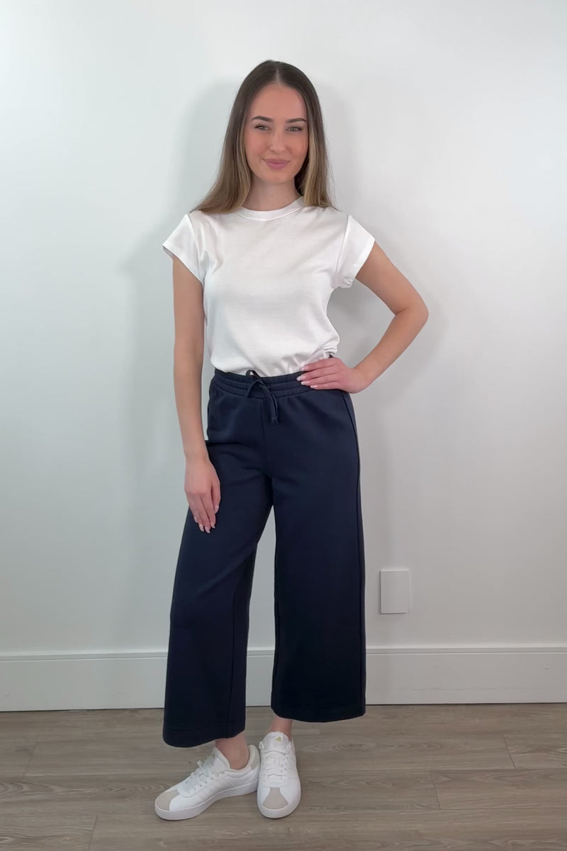 video of a woman wearing a navy ankle length wide leg pant