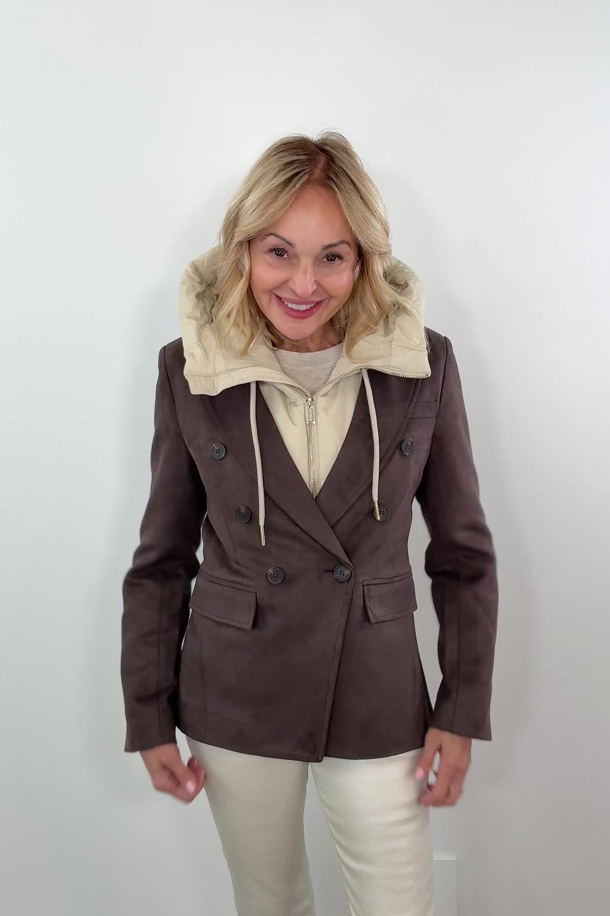 Video of a woman wearing a birch coloured hood under a brown double vested blazer