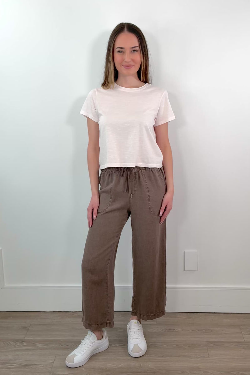 video of a woman wearing brown ankle length wide leg pants