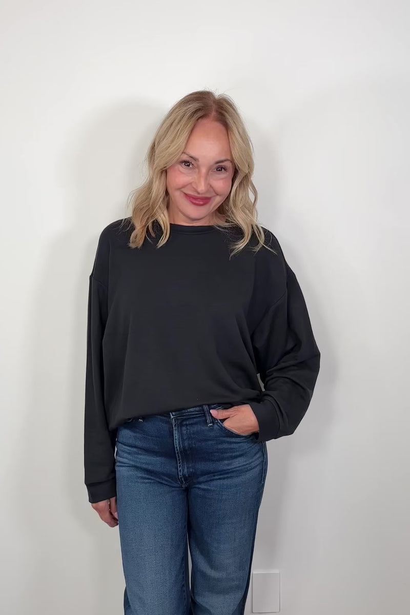 Video of a woman wearing a black pullover 