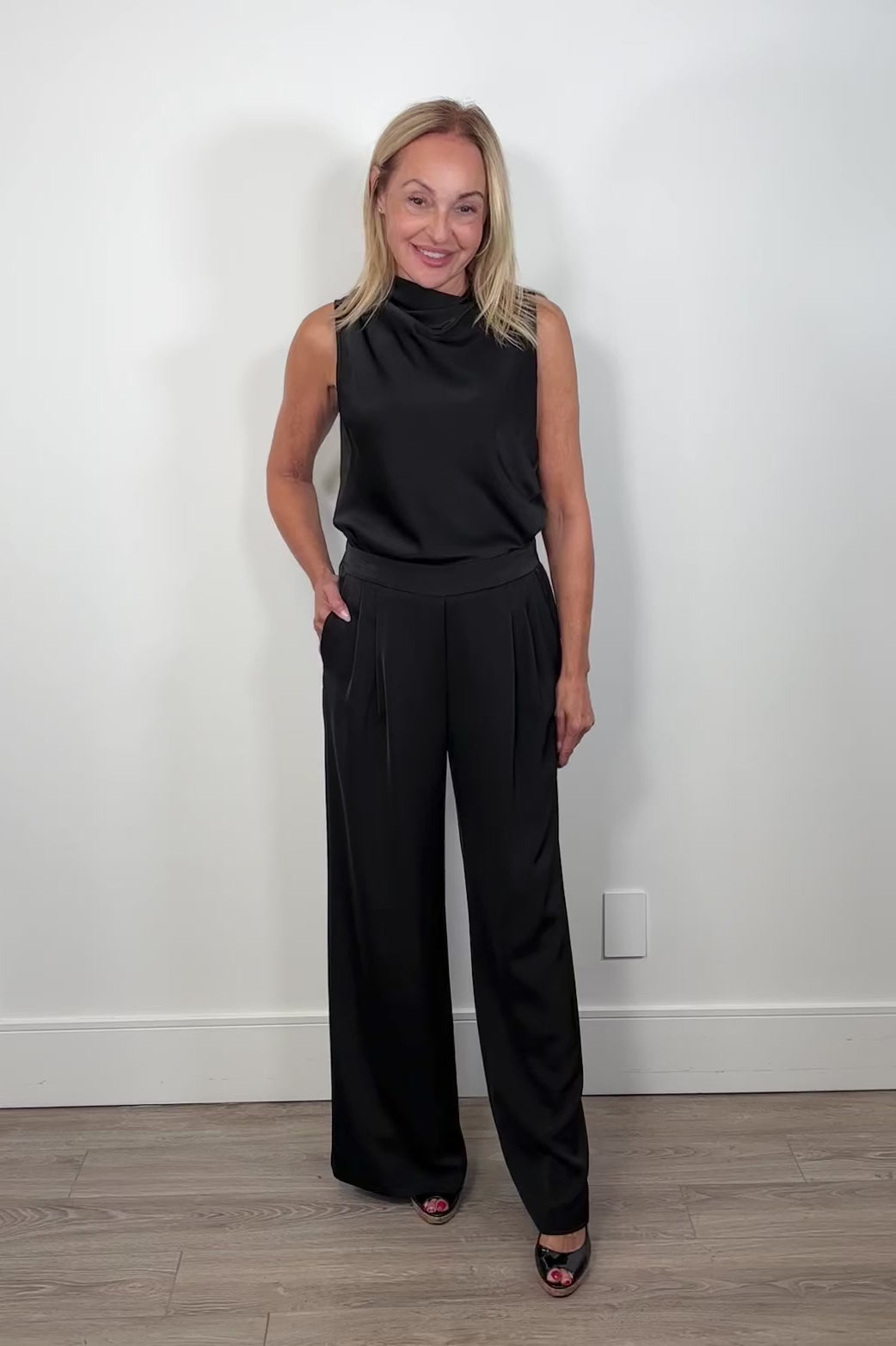Video of woman wearing a satin black wide leg pant
