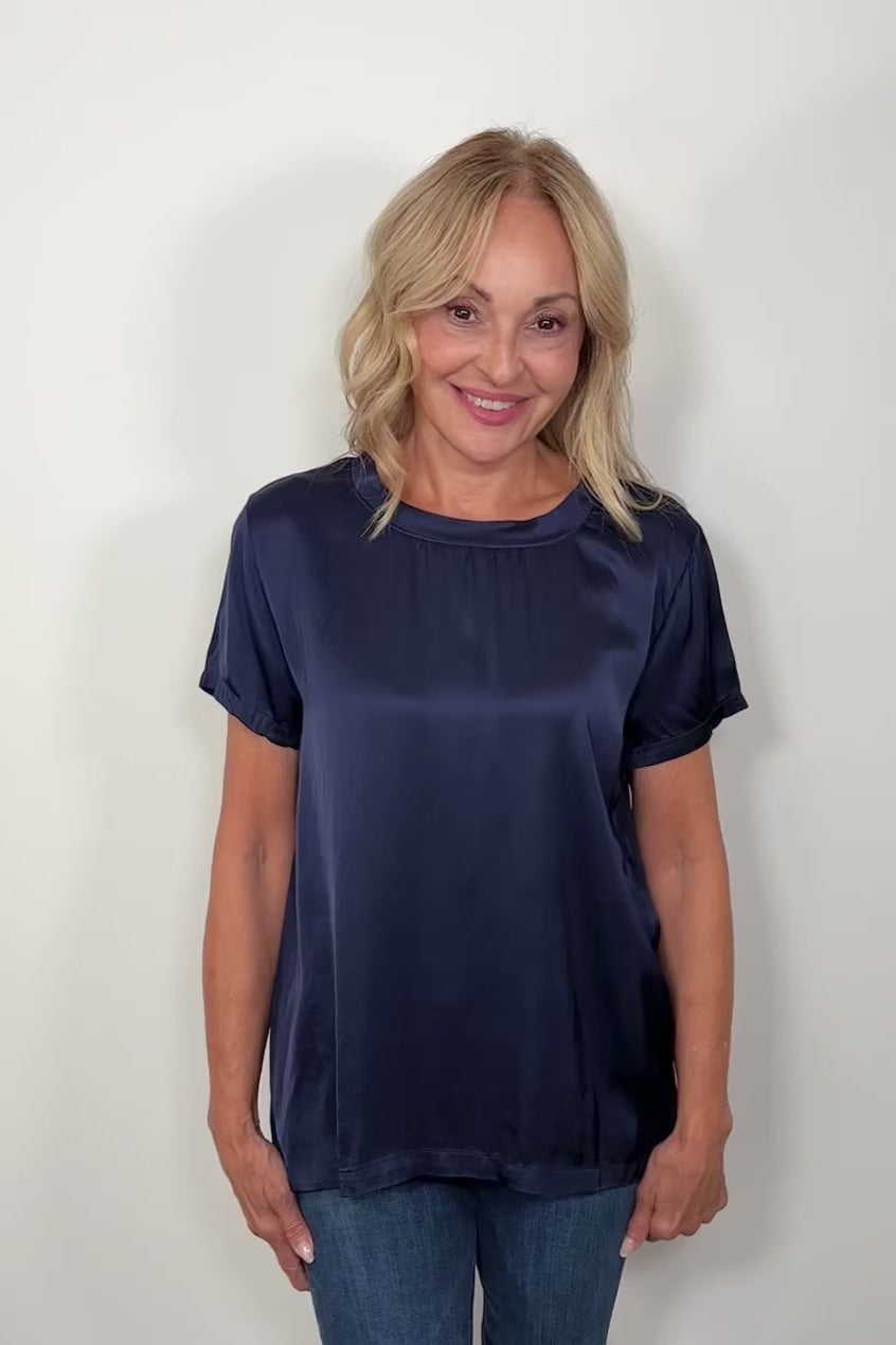 Video of woman wearing a satin navy blue shirt