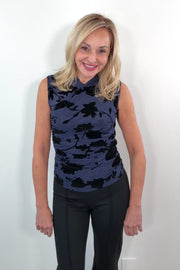 video of a woman wearing a sleeveless navy mesh top with black floral pattern 