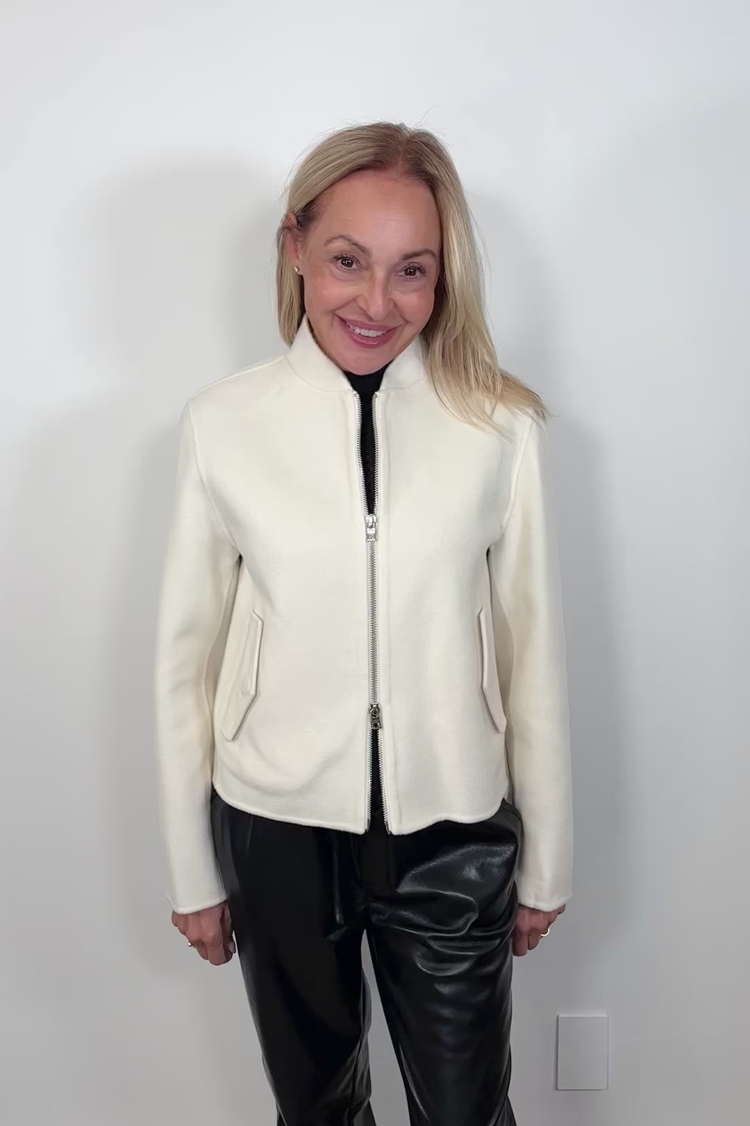 Video of woman wearing a white double zipper silk bomber jacket 