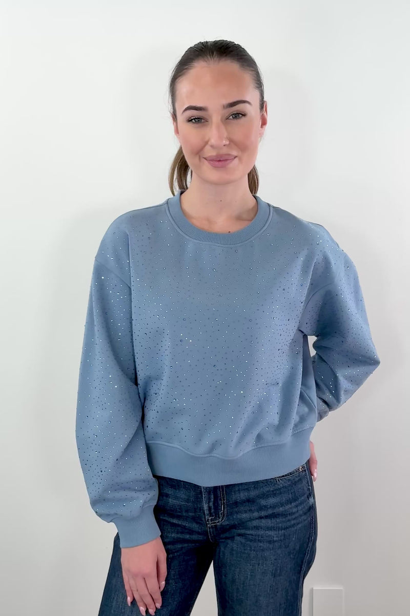 video of woman wearing a blue pullover with rhinestone details allover