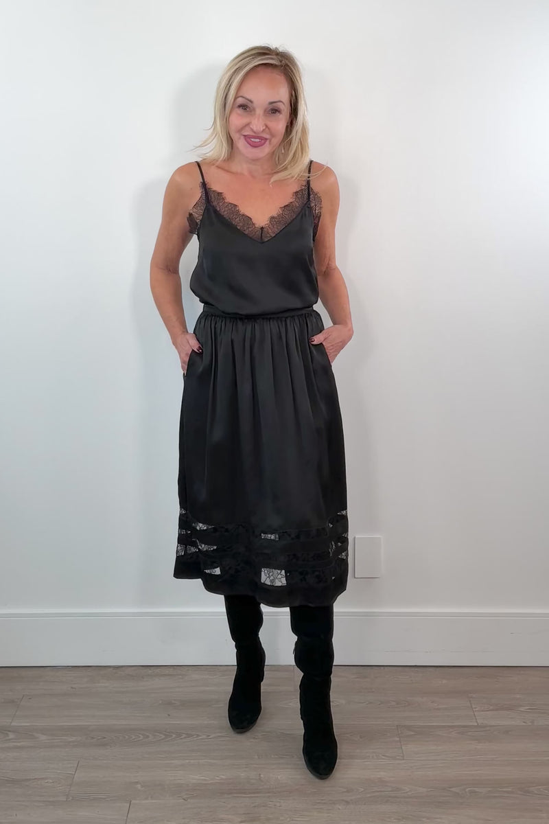 video of a woman wearing a black a-line inset lace midi skirt