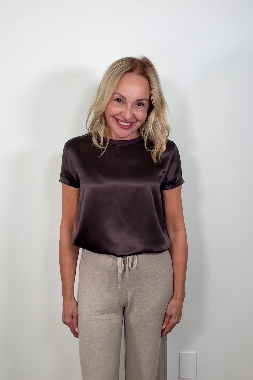 Video of a woman wearing a satin brown t-shirt