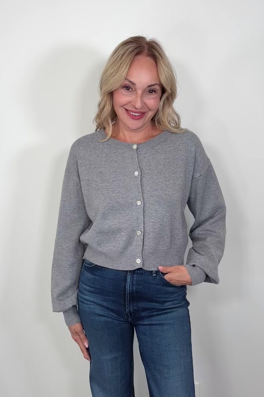 Video of a woman wearing gray cardigan with crystal buttons