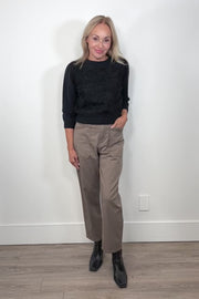 Video of woman wearing a pale brown pant with a black long sleeve top