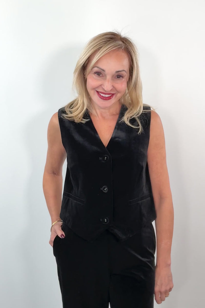 video of a woman wearing  a black velvet vest 