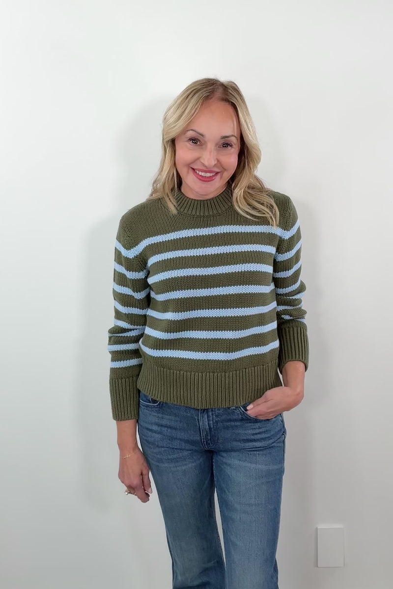 video of a woman wearing a green and blue striped sweater 