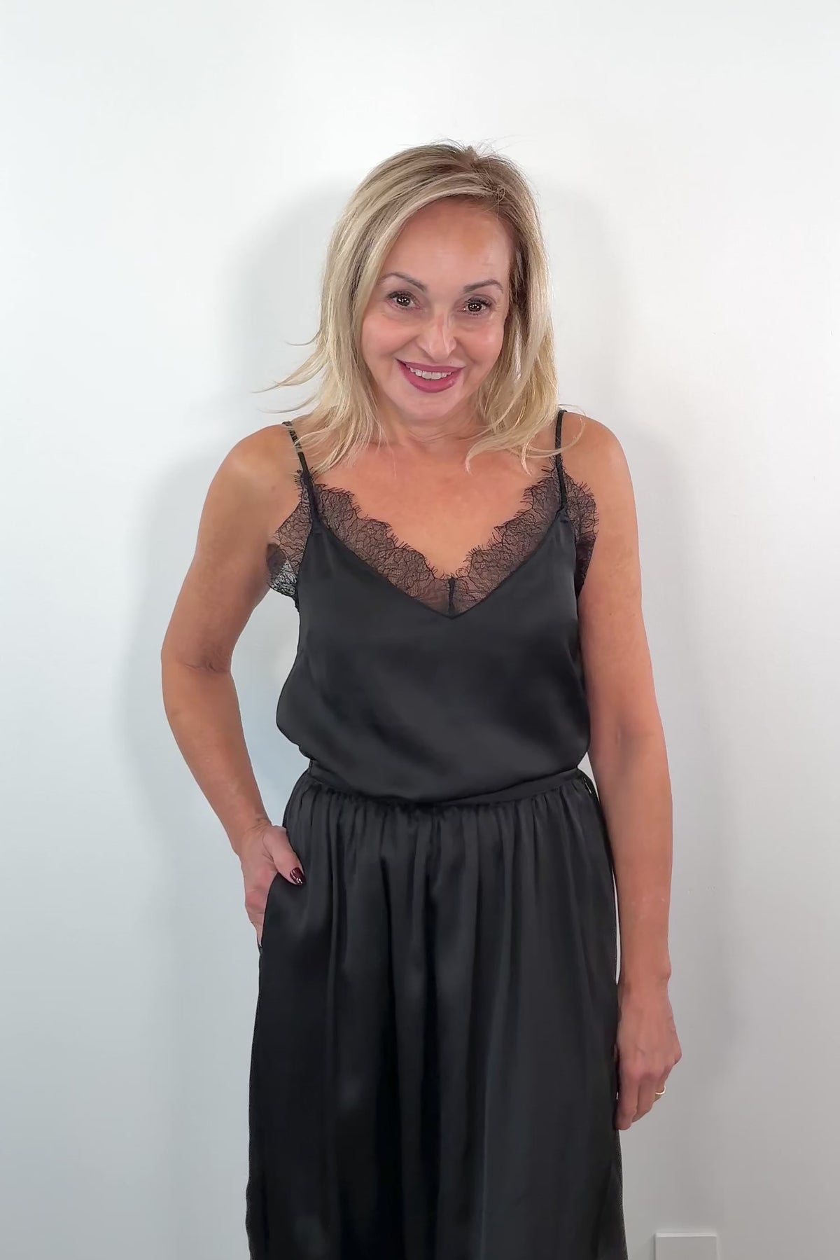 woman wearing a lace trimmed black satin cami