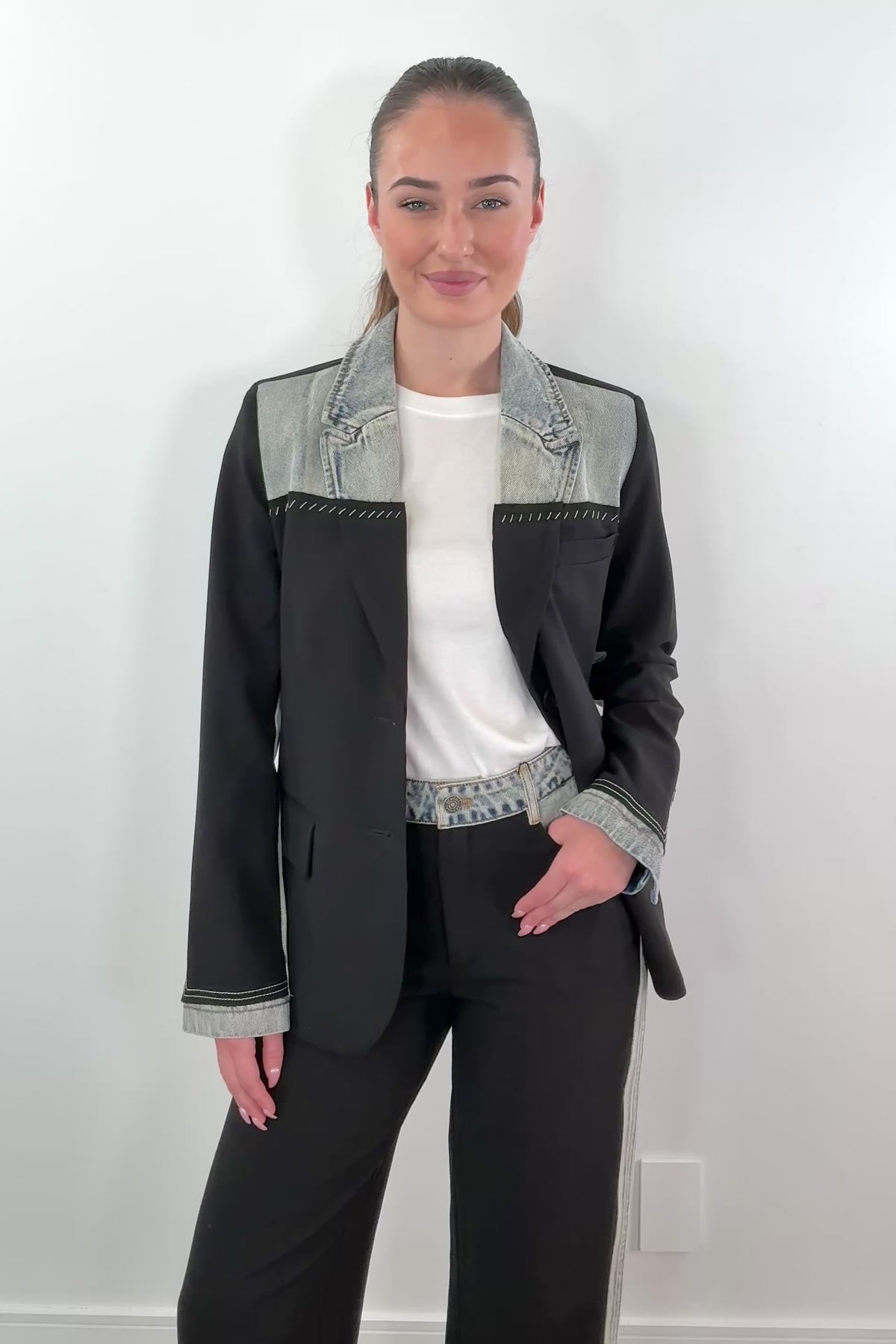 video of woman wearing a mixed denim fabric blazer in black with hints of light blue