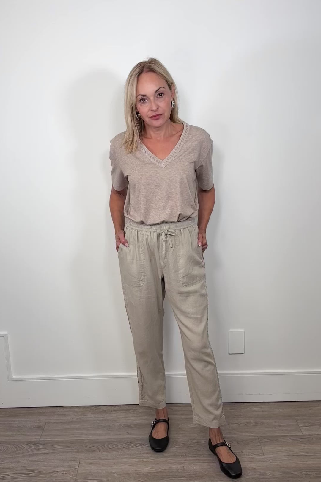 Video of woman wearing a cool beige straight pant with detailing on the side