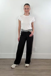 video of woman wearing black dress pants accented with light indigo denim