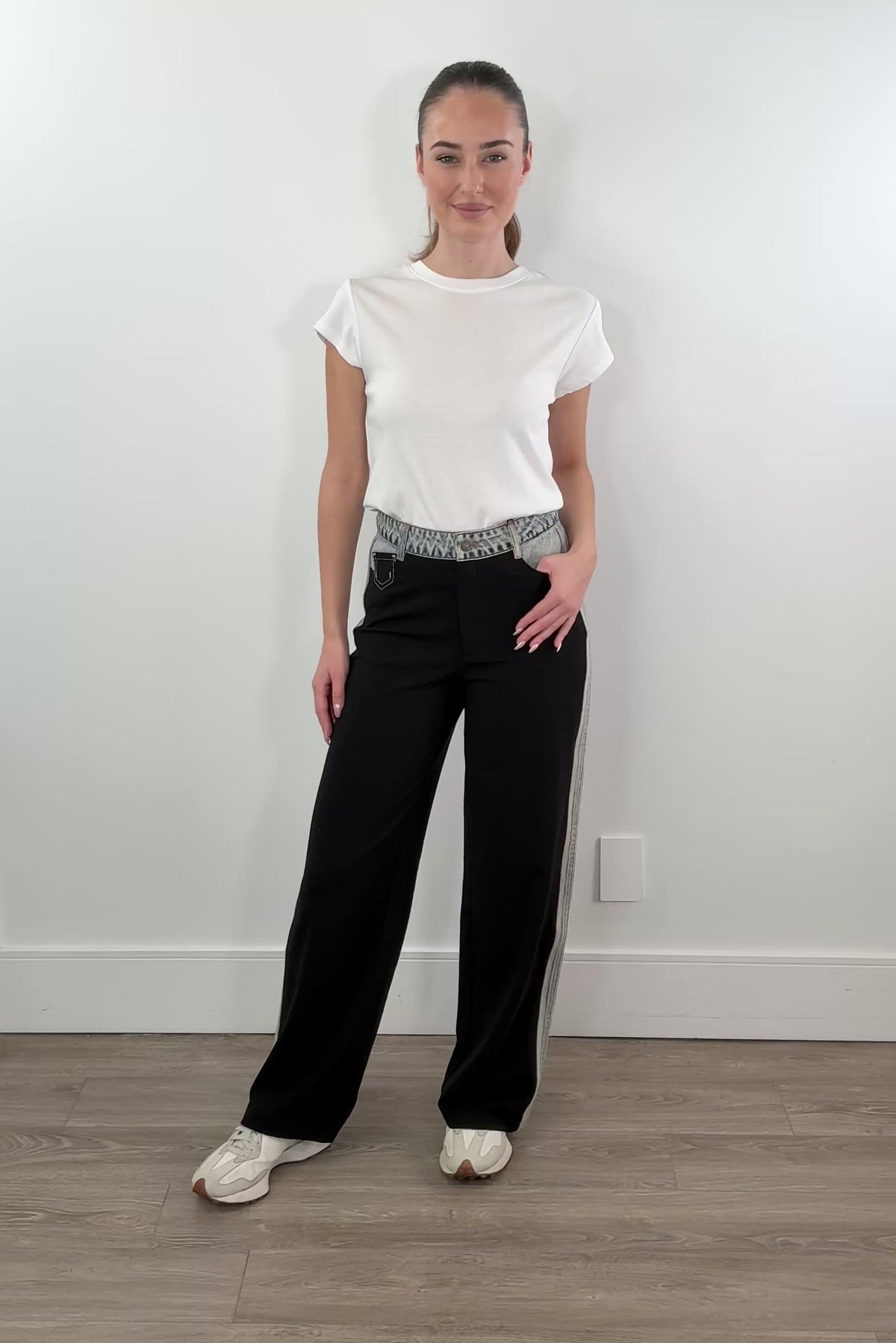 video of woman wearing black dress pants accented with light indigo denim
