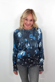 video of a woman wearing a blue and black floral pullover sweater 