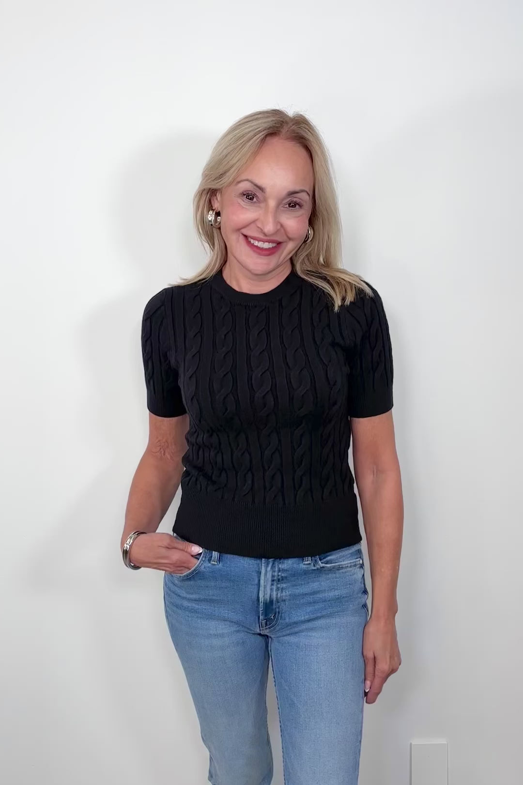 Video of woman wearing a black coloured cable knit top