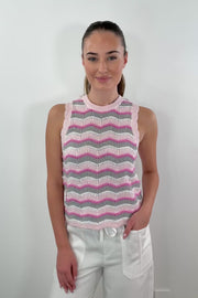 video of A woman wearing a knit vest with a zig zag stitch in a pink grey and white pattern