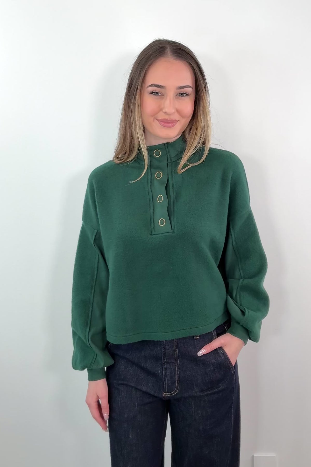 video of a woman wearing a green fleece Henley sweatshirt