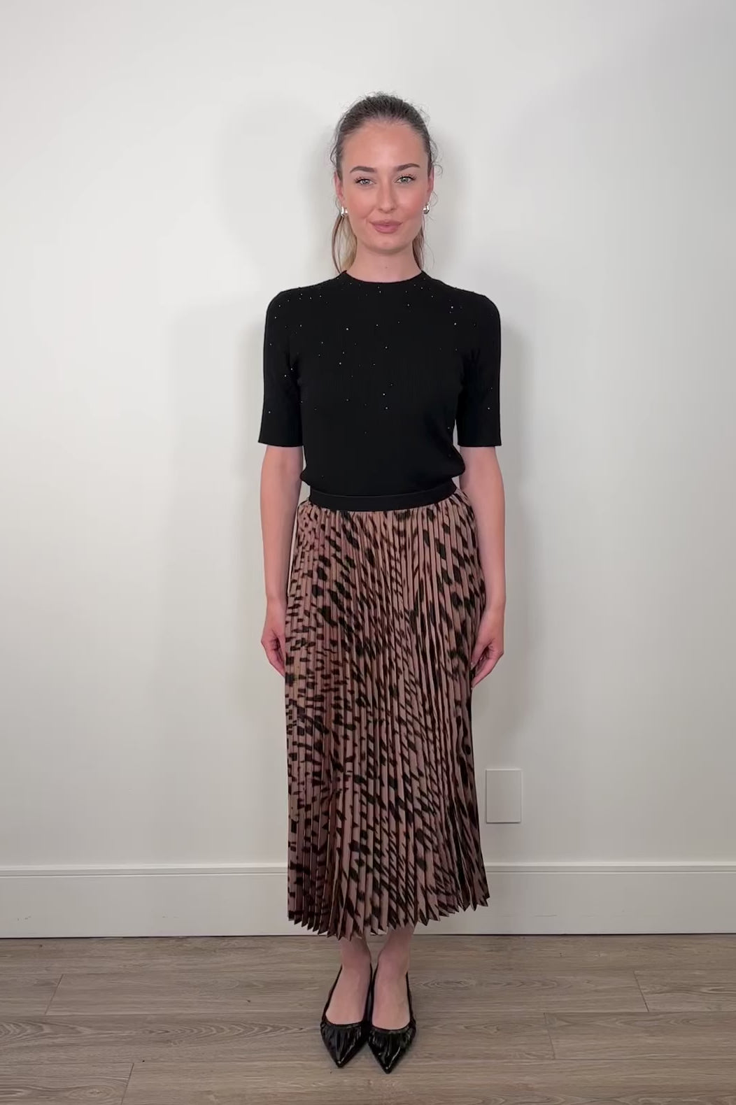 Video of a woman wearing a leopard printed midi skirt 