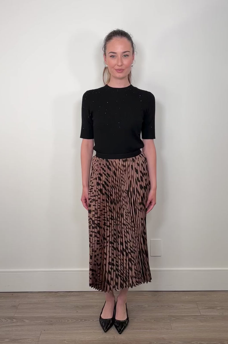 Video of a woman wearing a leopard printed midi skirt 