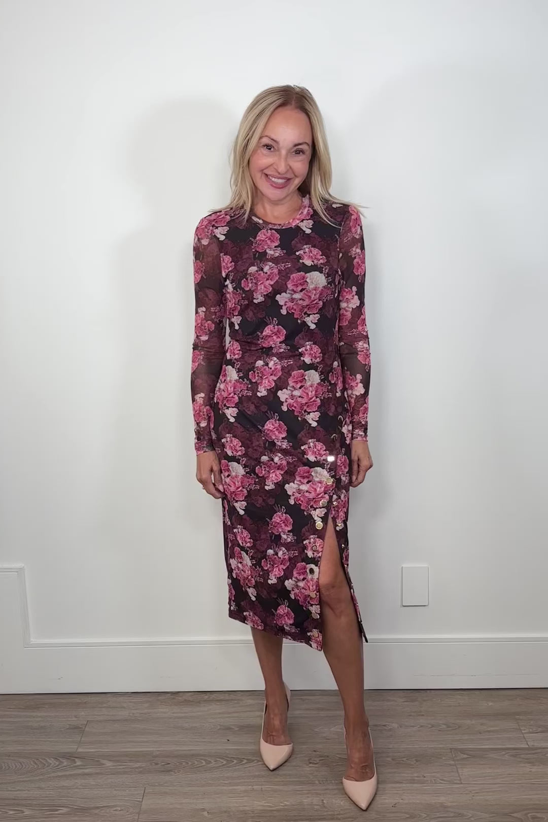 Woman wearing a midi floral mesh dress with a slit in the side
