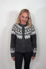 video of a woman wearing a dark gray button up cardigan with detailing on the op and cuffs