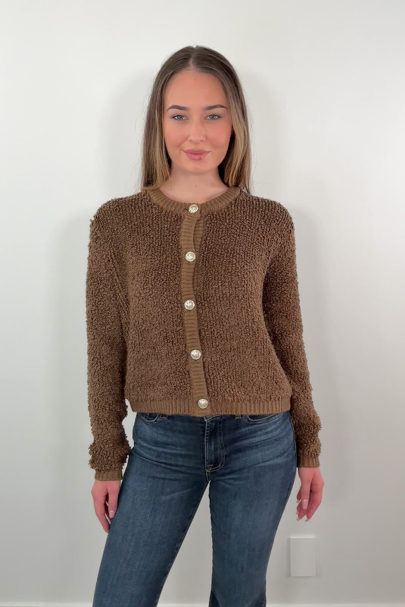 video of a woman wearing a warm brown textured cardigan