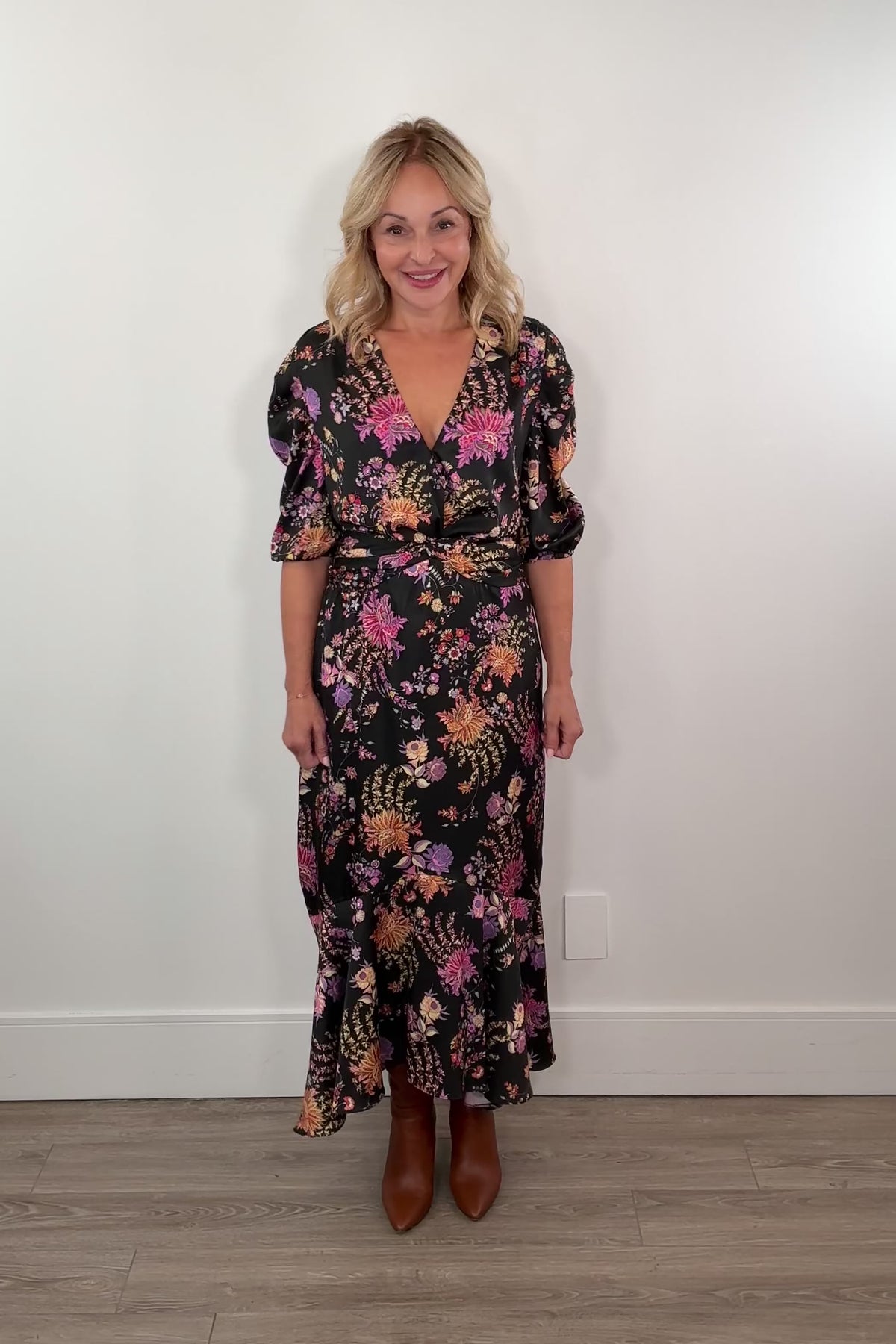 Video of a woman wearing a black dress with colourful floral patterns