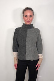 Video of woman wearing two toned gray with beige in the cuffs turtleneck sweater