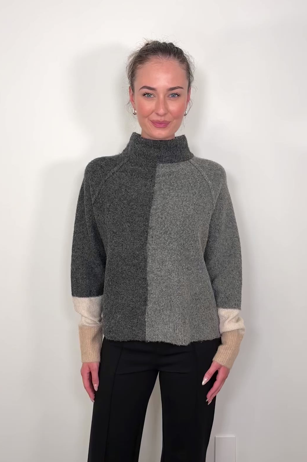 Video of woman wearing two toned gray with beige in the cuffs turtleneck sweater