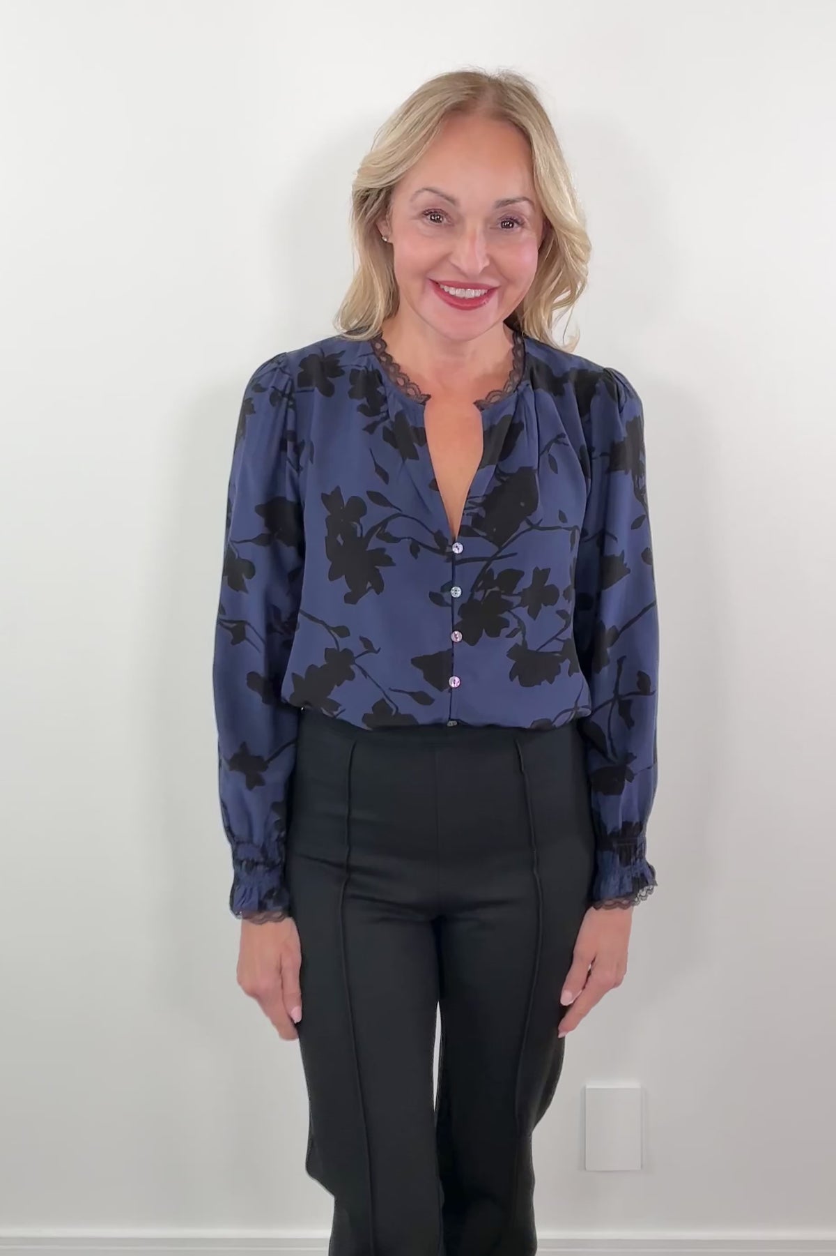video of a woman wearing a blue floral blouse with lace trim