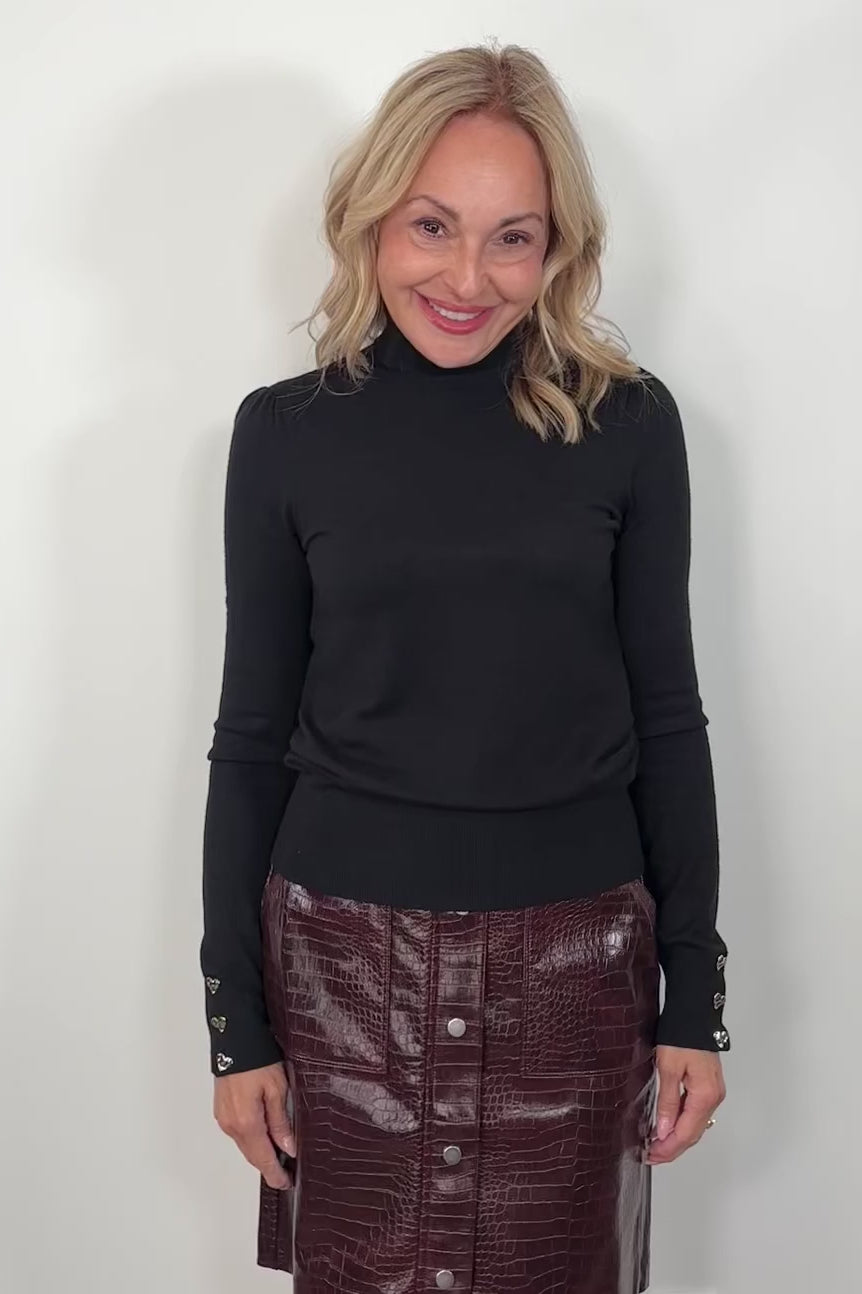 video of a woman wearing a black turtleneck and burgundy skirt against a white background