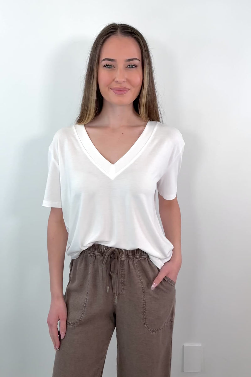 video of a woman wearing a white V-neck top