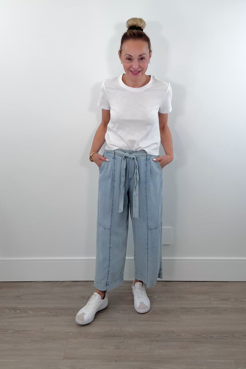 Video of a woman wearing light blue chambray wide-leg pants with a drawstring waist