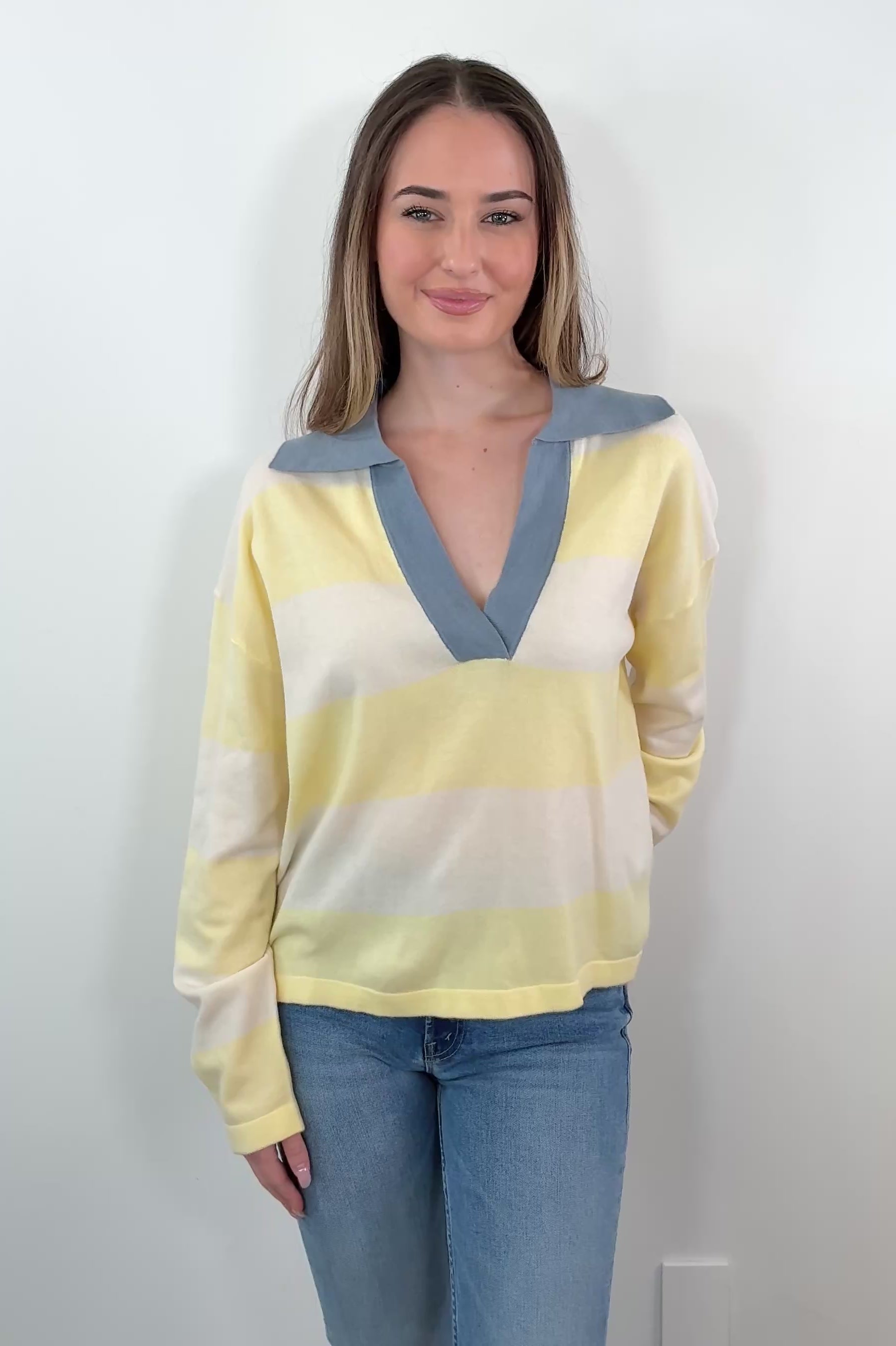 video of a woman wearing a yellow and white polo sweater