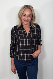 Video of a woman wearing  a black and white plaid shirt 