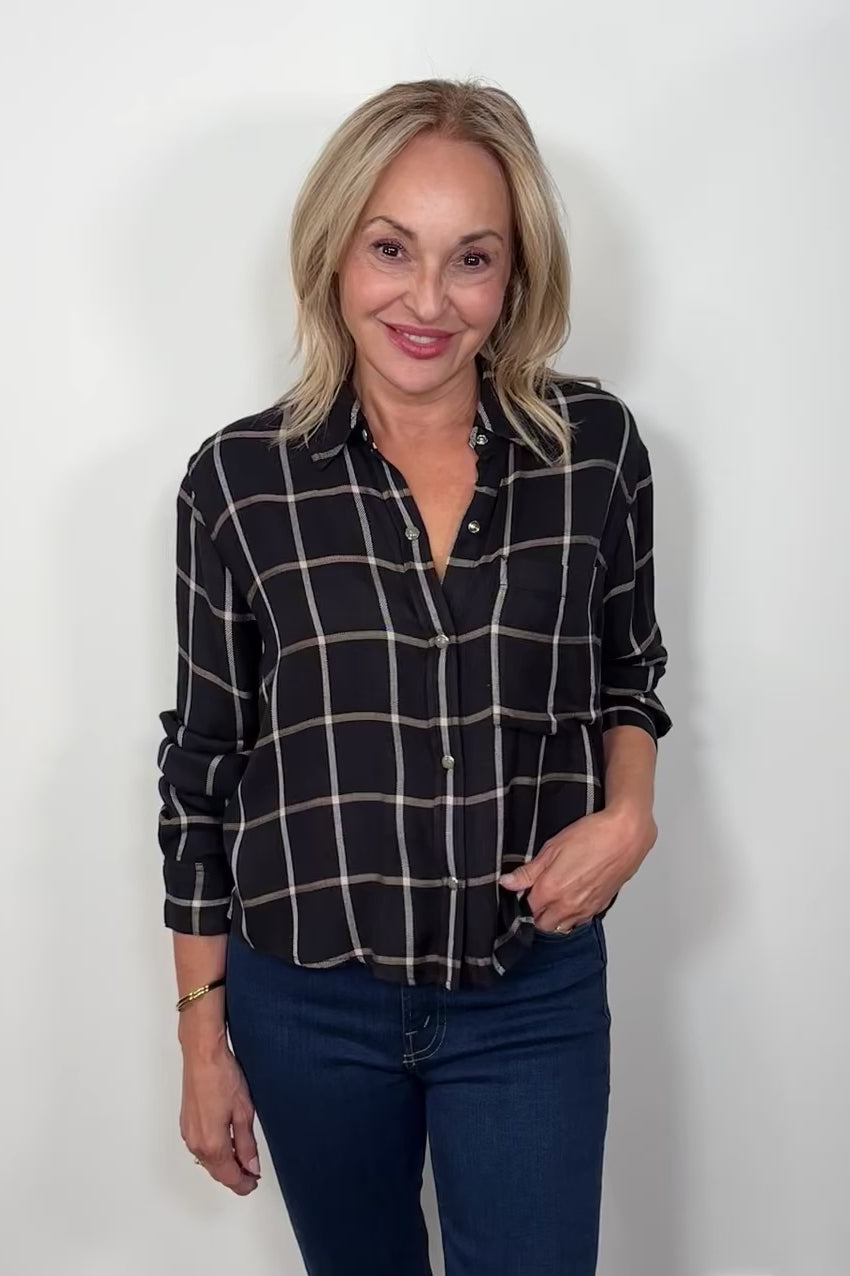 Video of a woman wearing  a black and white plaid shirt 