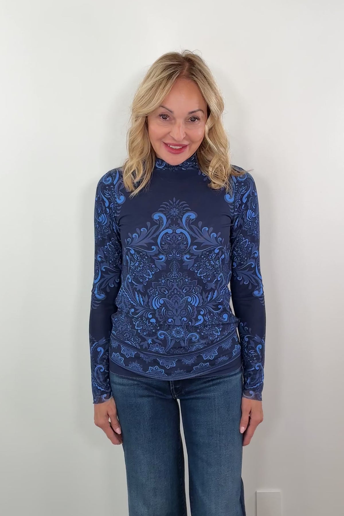 video of a woman wearing a long sleeve turtleneck mesh top with patterns